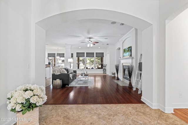 living room featuring ceiling fan, light tile patterned flooring, and ornamental molding