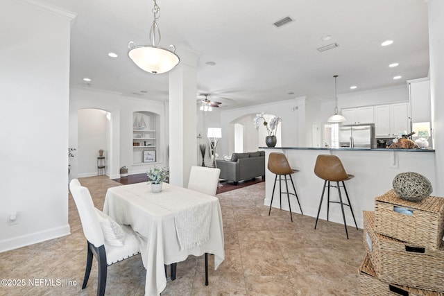 dining room featuring built in shelves, ceiling fan, and ornamental molding