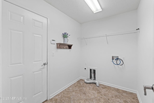 laundry room with electric dryer hookup, hookup for a washing machine, light tile patterned floors, and a textured ceiling