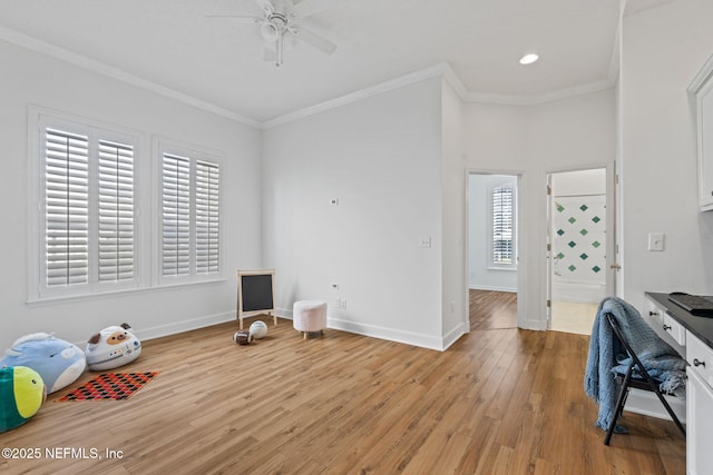 interior space featuring ceiling fan, light hardwood / wood-style floors, and ornamental molding