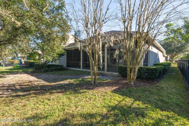 back of property with a sunroom and a yard