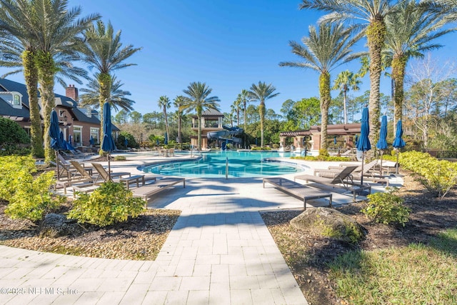 view of swimming pool with a patio area and a water slide