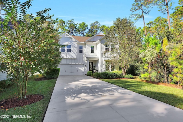 view of front of home with a balcony, a garage, and a front lawn