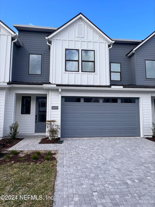 view of front of house featuring a garage, decorative driveway, and board and batten siding