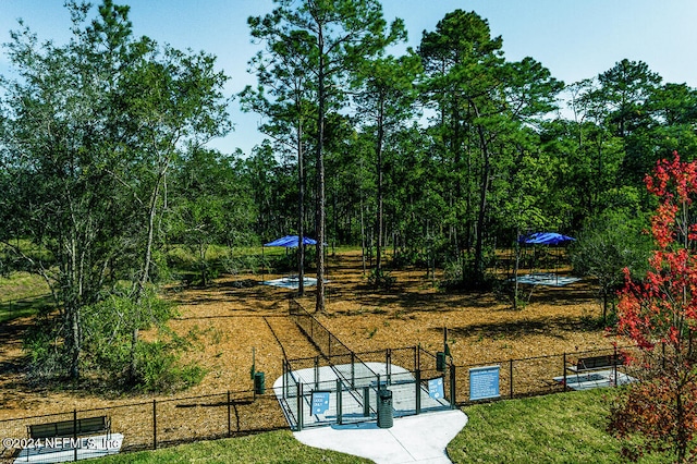 view of property's community featuring a gate, fence, and a lawn