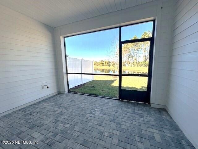 unfurnished sunroom featuring a water view