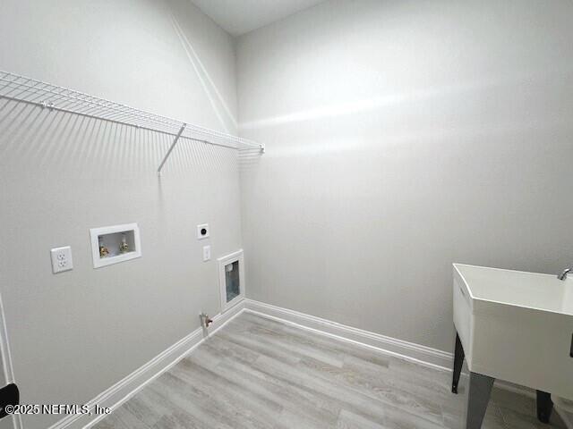 laundry area with hookup for a gas dryer, laundry area, washer hookup, wood finished floors, and baseboards