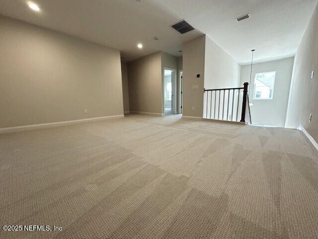 spare room featuring baseboards, recessed lighting, visible vents, and light colored carpet