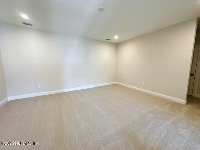 empty room featuring recessed lighting, visible vents, baseboards, and light colored carpet