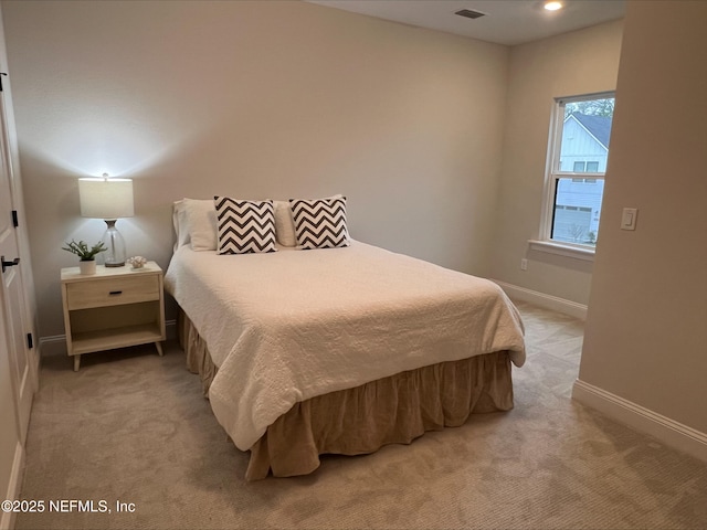 bedroom with light carpet, visible vents, and baseboards