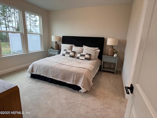 bedroom featuring baseboards and light colored carpet