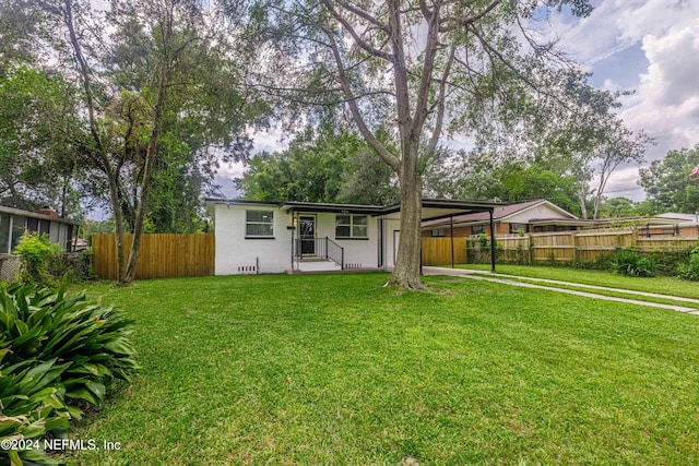 rear view of house with a carport and a lawn