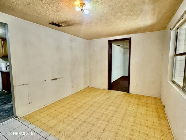 spare room featuring a textured ceiling and plenty of natural light