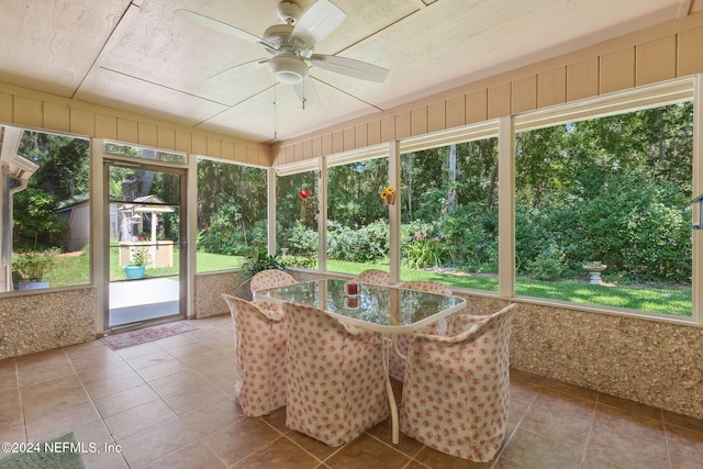 unfurnished sunroom featuring ceiling fan