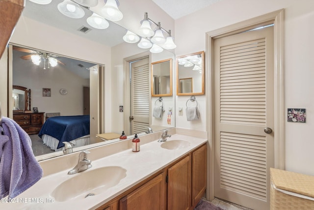 bathroom with ceiling fan, vanity, and a textured ceiling