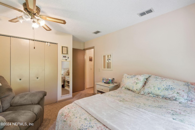 carpeted bedroom featuring a textured ceiling, a closet, and ceiling fan