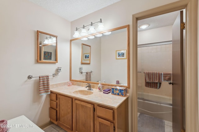 bathroom with tile patterned floors, vanity, bath / shower combo with glass door, and a textured ceiling