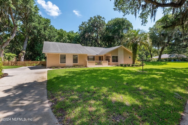 ranch-style house with covered porch and a front lawn