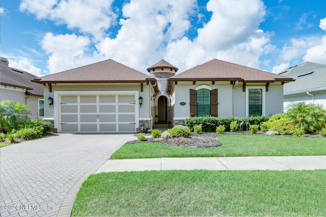 view of front of home with a front lawn and a garage