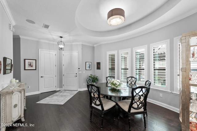 dining area with a textured ceiling, dark hardwood / wood-style floors, a raised ceiling, and crown molding