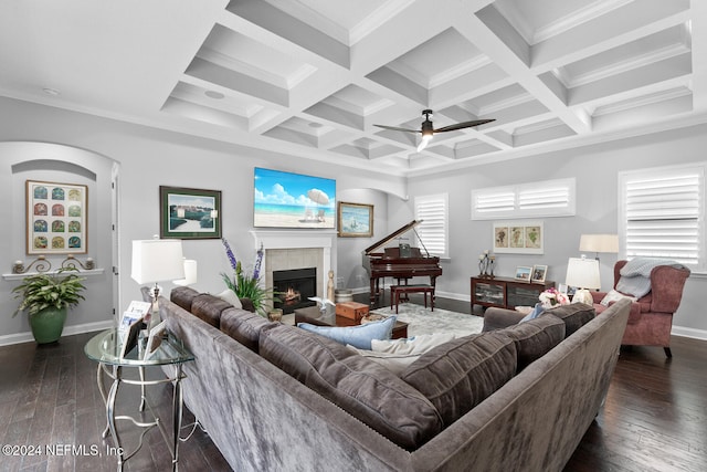 living room featuring beam ceiling, a tile fireplace, dark wood-type flooring, and coffered ceiling