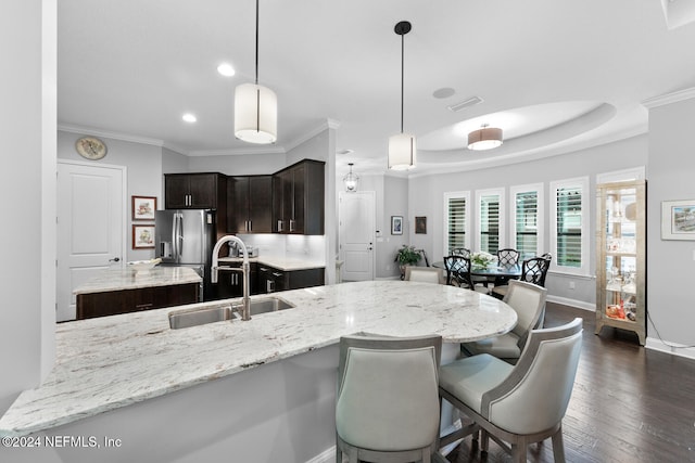 kitchen with dark wood-type flooring, sink, stainless steel fridge with ice dispenser, decorative light fixtures, and dark brown cabinetry