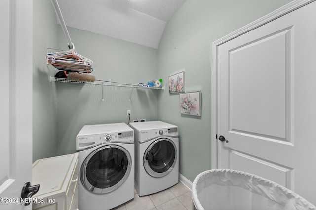 clothes washing area featuring independent washer and dryer, a textured ceiling, and light tile patterned flooring