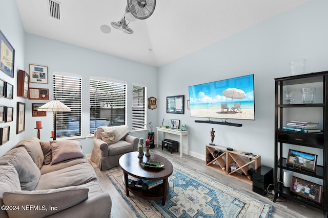 living room featuring light hardwood / wood-style floors and vaulted ceiling