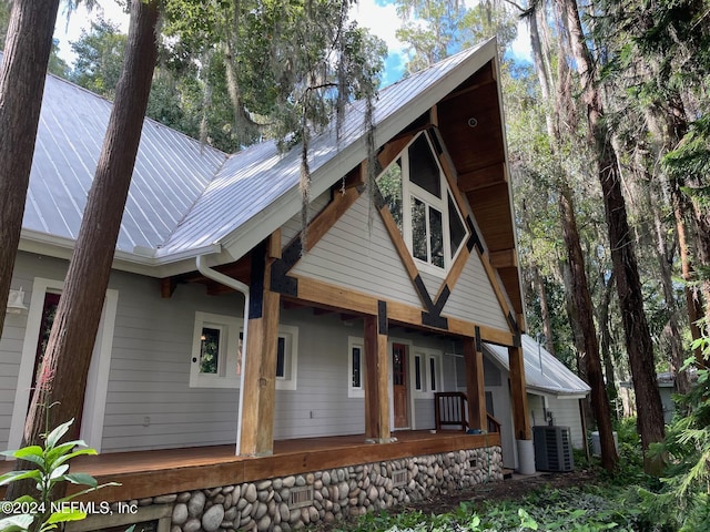 rear view of property featuring central air condition unit and covered porch