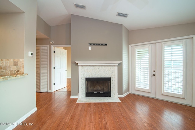 300 Sandiron Cir Unit 333, Ponte Vedra Beach, FL 32082 - unfurnished living room with wood finished floors, a fireplace with flush hearth, lofted ceiling, and french doors