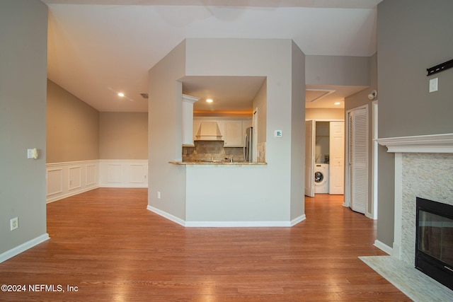 unfurnished living room with light hardwood / wood-style floors and washer / dryer