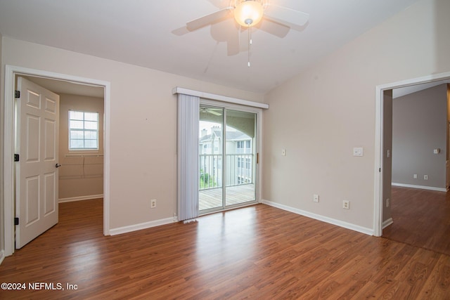 empty room with dark hardwood / wood-style flooring, ceiling fan, plenty of natural light, and lofted ceiling