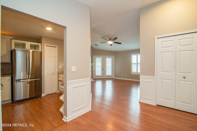 kitchen with stainless steel fridge, light hardwood / wood-style flooring, ceiling fan, and french doors