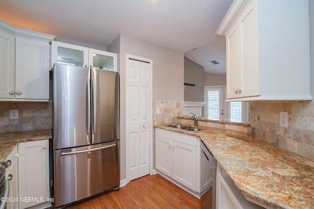 300 Sandiron Cir Unit 333, Ponte Vedra Beach, FL 32082 - kitchen featuring stainless steel appliances, backsplash, white cabinetry, light wood-type flooring, and glass insert cabinets