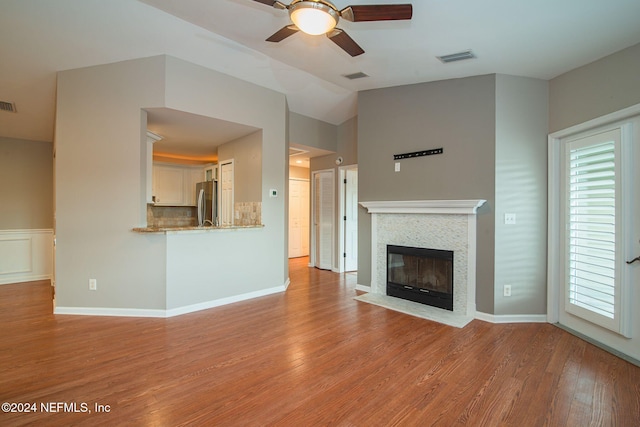 unfurnished living room with vaulted ceiling, light hardwood / wood-style flooring, and ceiling fan