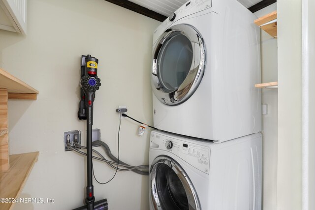 washroom featuring stacked washer and clothes dryer