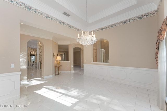 spare room with crown molding and a notable chandelier