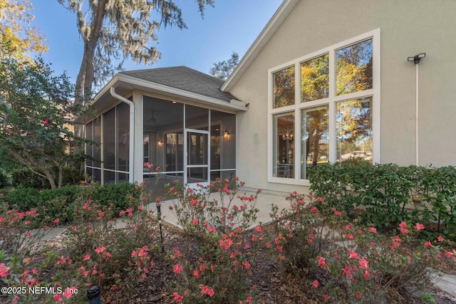 rear view of property featuring a sunroom