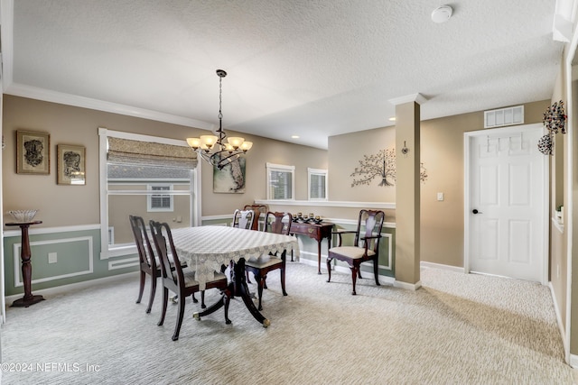 dining room with light carpet, a chandelier, a textured ceiling, and ornamental molding