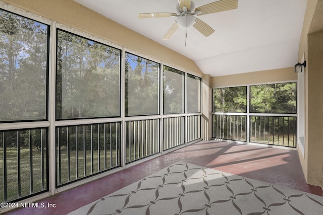 unfurnished sunroom featuring ceiling fan, plenty of natural light, and vaulted ceiling