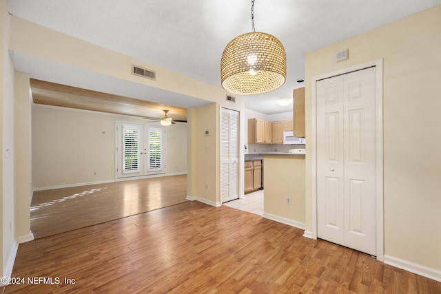 kitchen featuring hanging light fixtures, light hardwood / wood-style floors, french doors, and light brown cabinets