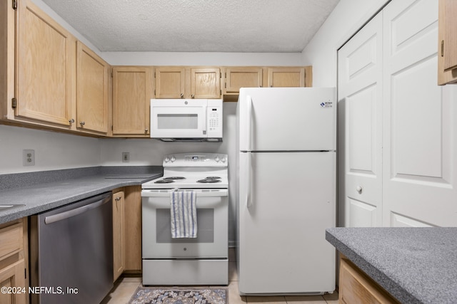 kitchen featuring a textured ceiling, light brown cabinets, light tile patterned floors, and white appliances