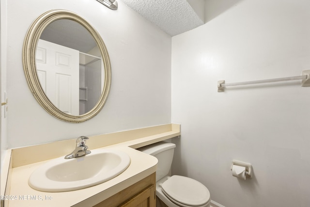 bathroom featuring vanity, toilet, and a textured ceiling