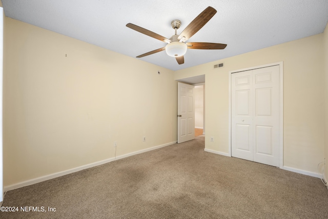 unfurnished bedroom with carpet flooring, ceiling fan, and a closet