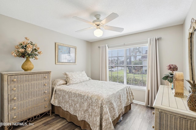 bedroom with a ceiling fan, a textured ceiling, and wood finished floors