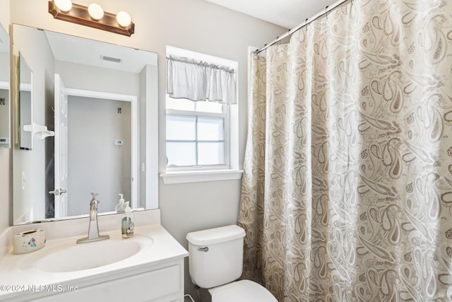 full bathroom featuring toilet, vanity, and visible vents