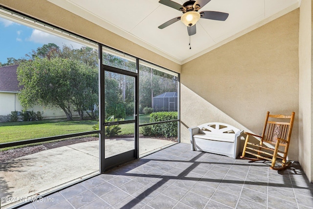 unfurnished sunroom featuring a ceiling fan