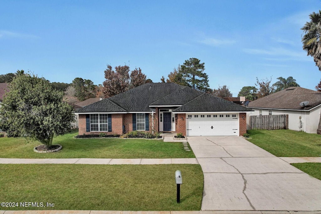 single story home featuring a front yard and a garage