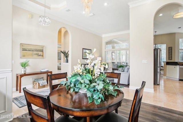 tiled dining area featuring recessed lighting, arched walkways, and ornamental molding