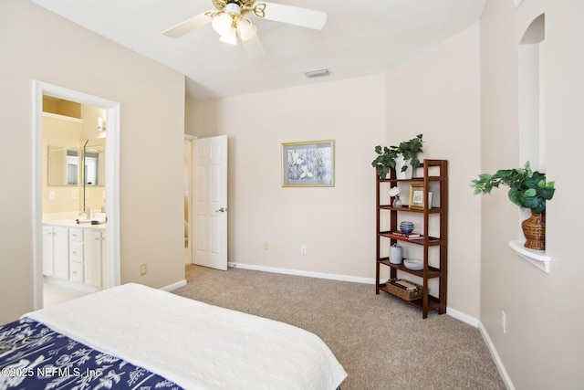 bedroom with visible vents, baseboards, ceiling fan, light colored carpet, and connected bathroom